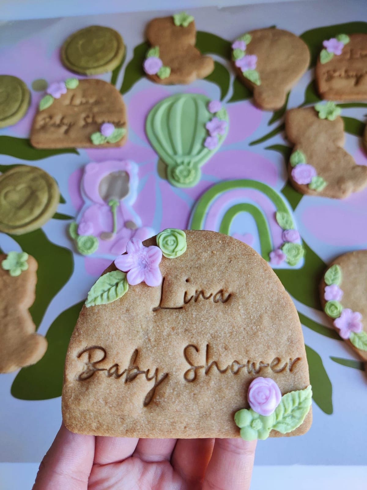 Biscuit sablé arche gravé « Lina Baby Shower », orné de fleurs en pâte à sucre rose et vert